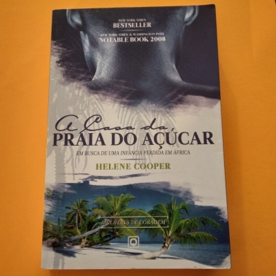 Capa do livro A Casa da Praia do Açúcar com imagem de criança e praia