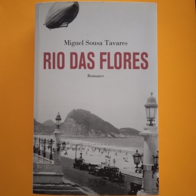 Capa do livro Rio das Flores de Miguel Sousa Tavares com uma fotografia de praia em preto e branco