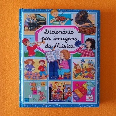 Capa de livro infantil azul com ilustrações de crianças a tocar instrumentos e título Dicionário por imagens da Música