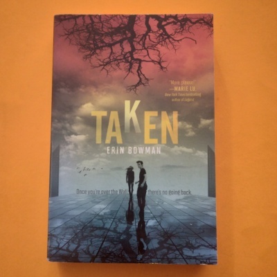 Capa do livro 'TAKEN' de Erin Bowman com figuras humanas e cenário refletido