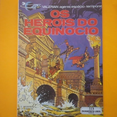 Capa de livro com título OS HEROIS DO EQUINOCIO e ilustração de edifícios e figuras voadoras