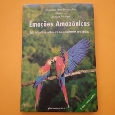 Capa de livro com duas araras vermelhas e texto 'Emoções Amazónicas'