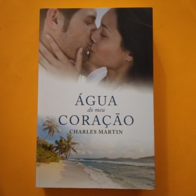 Livro 'Água do meu Coração' de Charles Martin com casal a beijar e paisagem de praia
