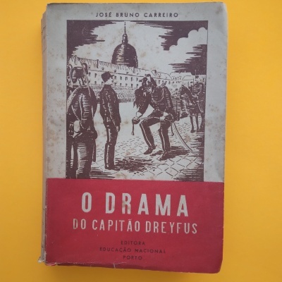 Capa de livro antigo 'O DRAMA DO CAPITÃO DREYFUS' com ilustração de militares em sépia sobre fundo amarelo
