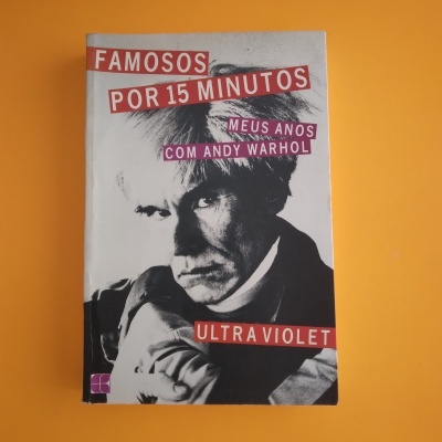 Capa de livro com foto de Andy Warhol e texto em vermelho e branco