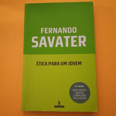 Capa de livro verde com título e autor em texto branco e preto, selo cinza, sobre fundo laranja