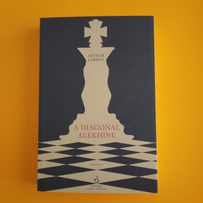 Livro com capa azul escura e branco com peça de xadrez e texto A DIAGONAL ALEKHINE