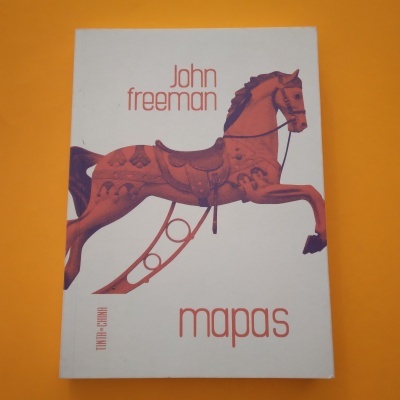 Livro com capa branca, cavalo de madeira e texto Mapas de John Freeman.