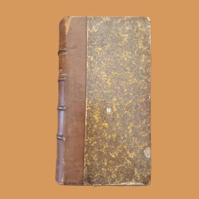 Livro antigo com lombada em couro castanho e capas marmoreadas amarelo e cinza