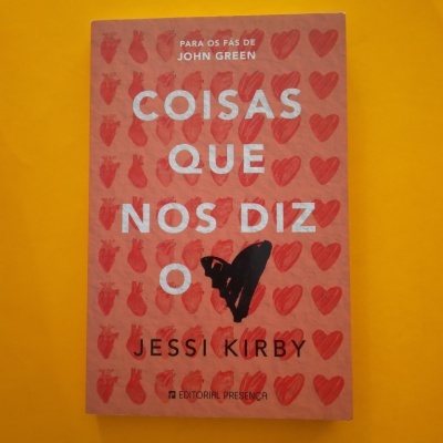 Livro 'Coisas Que Nos Diz O' de Jessi Kirby com capa vermelha e corações desenhados em fundo amarelo