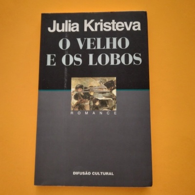 Capa do livro 'O Velho e os Lobos' de Julia Kristeva com fundo preto e cinzento e pequena imagem central