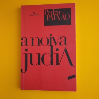 Livro vermelho com texto preto sobre fundo amarelo