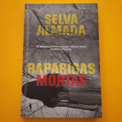 Capa de livro 'SELVA ALMADA RAPARIGAS MORTAS' com imagem em preto e branco de rapariga deitada e ramos secos de fundo
