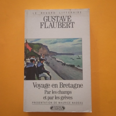 Livro 'Voyage en Bretagne' de Gustave Flaubert com ilustração de praia e pessoas