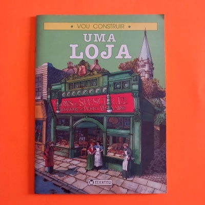 Capa de livro ilustrada de cor verde com fachada de loja e texto em português e inglês.