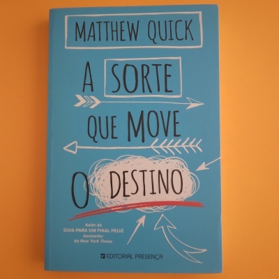 Capa de livro azul com texto e setas, fundo laranja