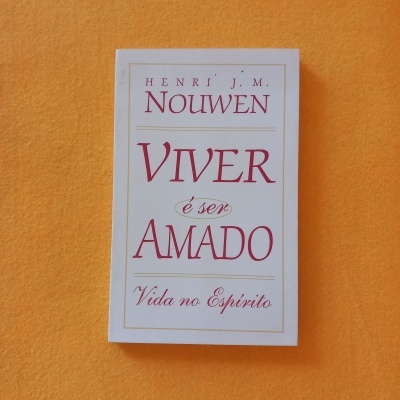 Livro com capa branca e letras vermelhas e douradas, título Viver é ser amado de Henri J.M. Nouwen