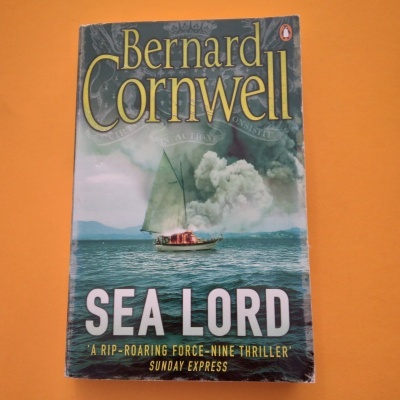 Livro 'Sea Lord' de Bernard Cornwell com barco no mar e fumo ao fundo