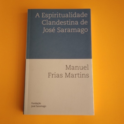 Capa de livro azul e branca com título e autor, sobre fundo laranja.