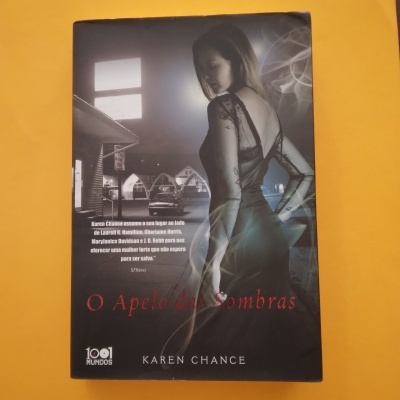 Capa do livro 'O Apelo das Sombras' de Karen Chance com imagem de mulher de costas em vestido preto