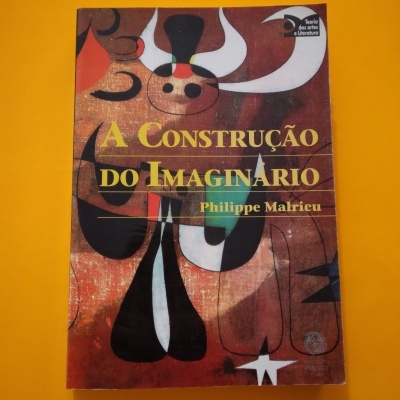 Livro 'A Construção do Imaginário' com capa abstrata em tons castanhos, vermelhos e pretos