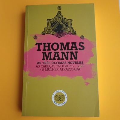 Capa de livro verde-oliva com título rosa e texto preto, selo circular.