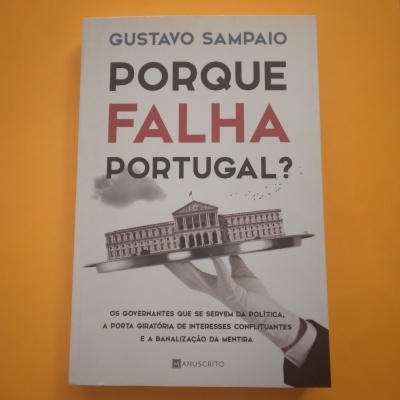 Capa de livro branco com título e imagem de edifício numa bandeja