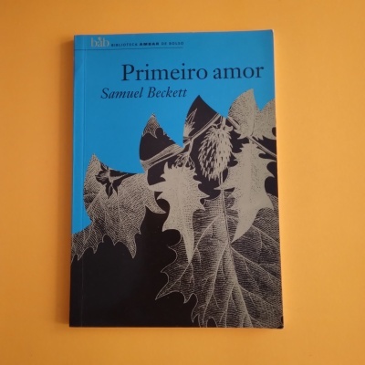 Capa de livro azul e preta com folhas desenhadas e texto Primeiro amor Samuel Beckett