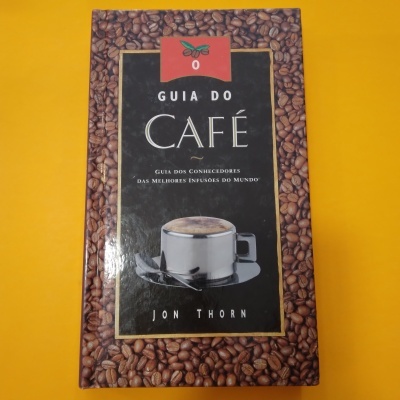 Capa do livro Guia do Café com grãos de café e foto de chávena e colher