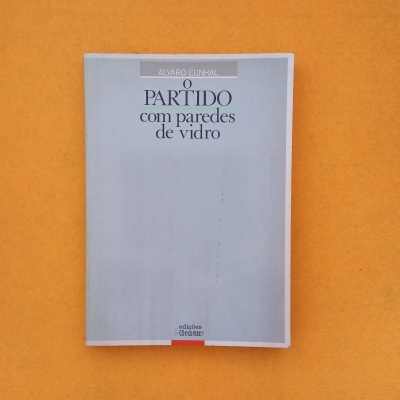 Livro 'O PARTIDO com paredes de vidro' sobre fundo laranja