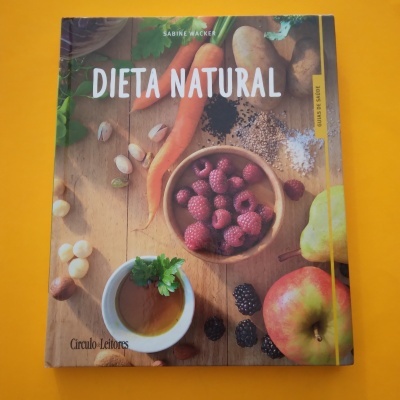 Capa do livro 'Dieta Natural' com frutas, legumes e chá numa superfície de madeira