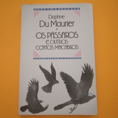 Capa de livro branca com título e três pássaros pretos e cinzentos em voo