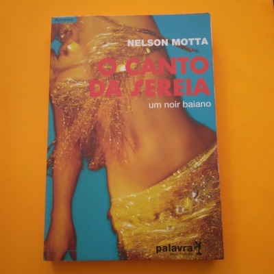 Capa de livro azul e laranja com mulher em tecido dourado e texto em vermelho e branco