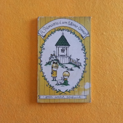 Livro infantil amarelo com desenho de crianças e gato e texto em português