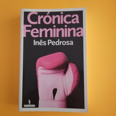 Livro Crónica Feminina com luva de boxe rosa na capa sobre fundo laranja