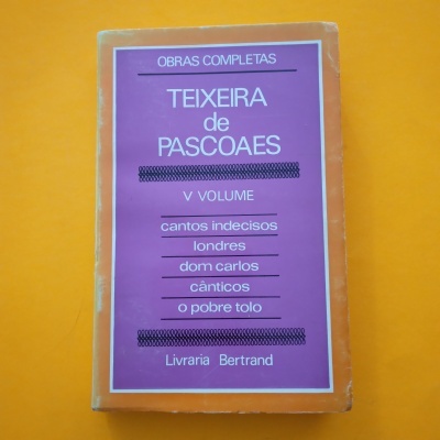 Livro 'Obras Completas Teixeira de Pascoaes V Volume' com capa laranja e lilás sobre fundo laranja