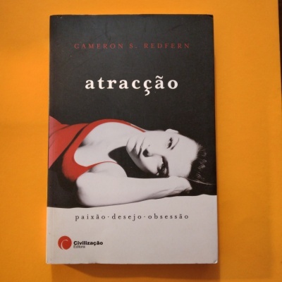 Capa do livro 'atração' com imagem de mulher deitada em fundo preto e branco, texto em vermelho e branco, fundo laranja.