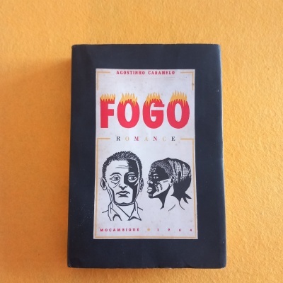 Livro com capa preta e etiqueta branca com ilustrações e texto 'FOGO'.