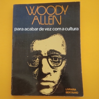 Capa de livro preto com rosto amarelo estilizado e texto laranja e branco