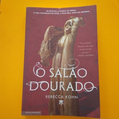 Capa de livro 'O Salão Dourado' com imagem de mulher vestida tradicionalmente em fundo vermelho