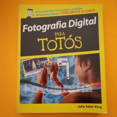 Capa do livro Fotografia Digital para Totós em fundo amarelo e preto com imagem de pessoa a tirar fotografia digital