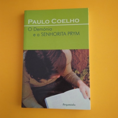 Capa de livro verde e fotografica com texto de Paulo Coelho e título em português.
