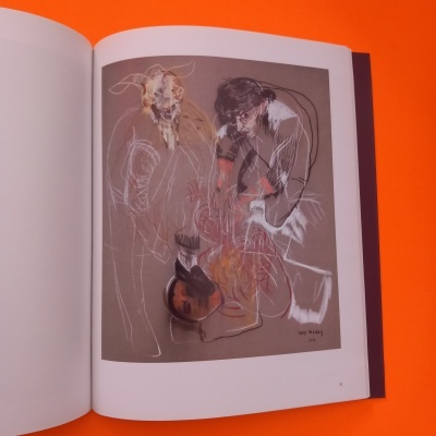 Página de livro aberta com pintura abstrata colorida, fundo castanho