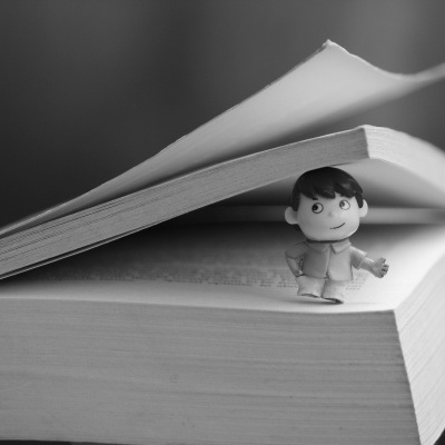 Livro aberto com uma pequena figura de brinquedo entre as páginas