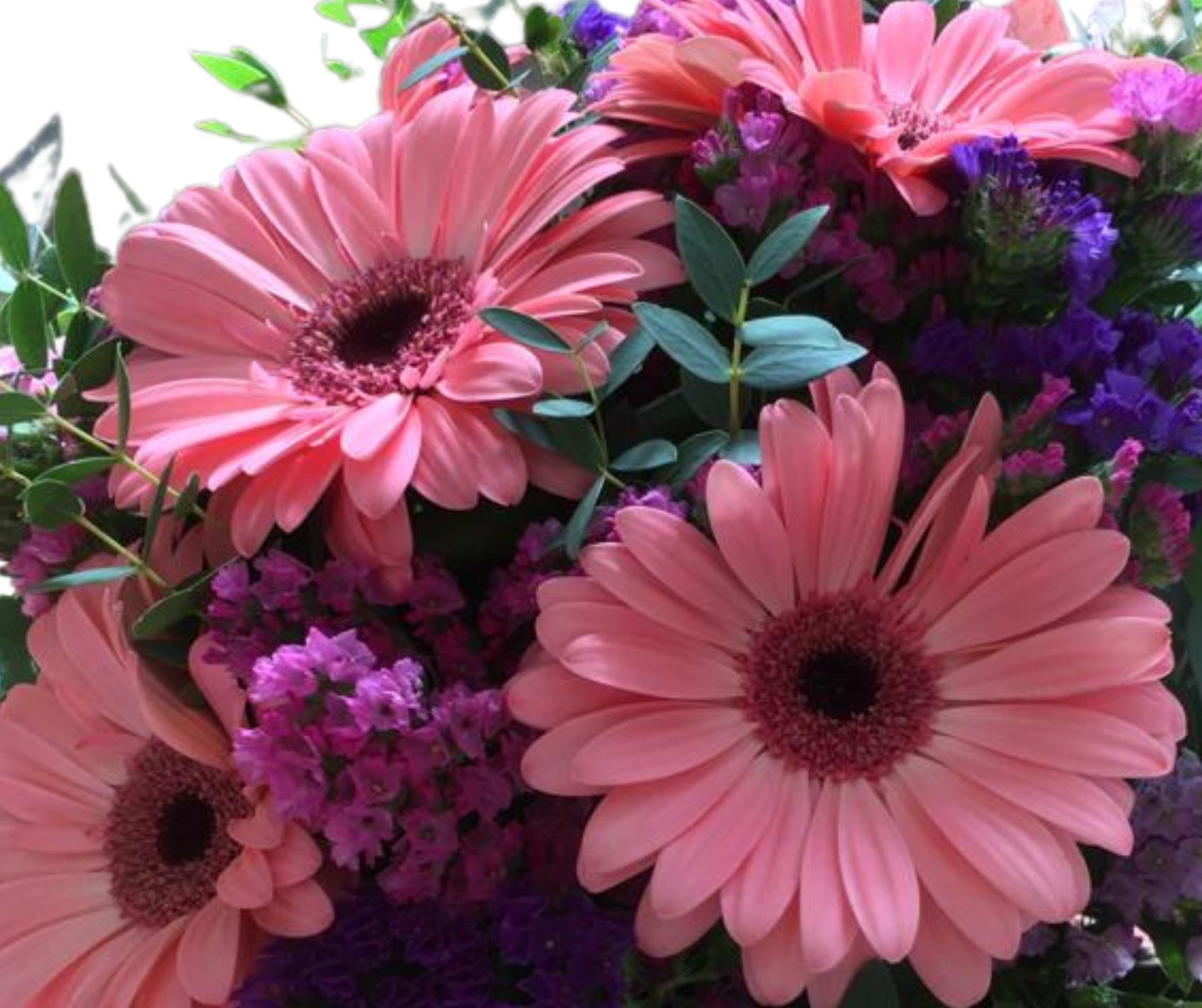 Bouquet de flores com gerberas cor-de-rosa e flores roxas com folhas verdes
