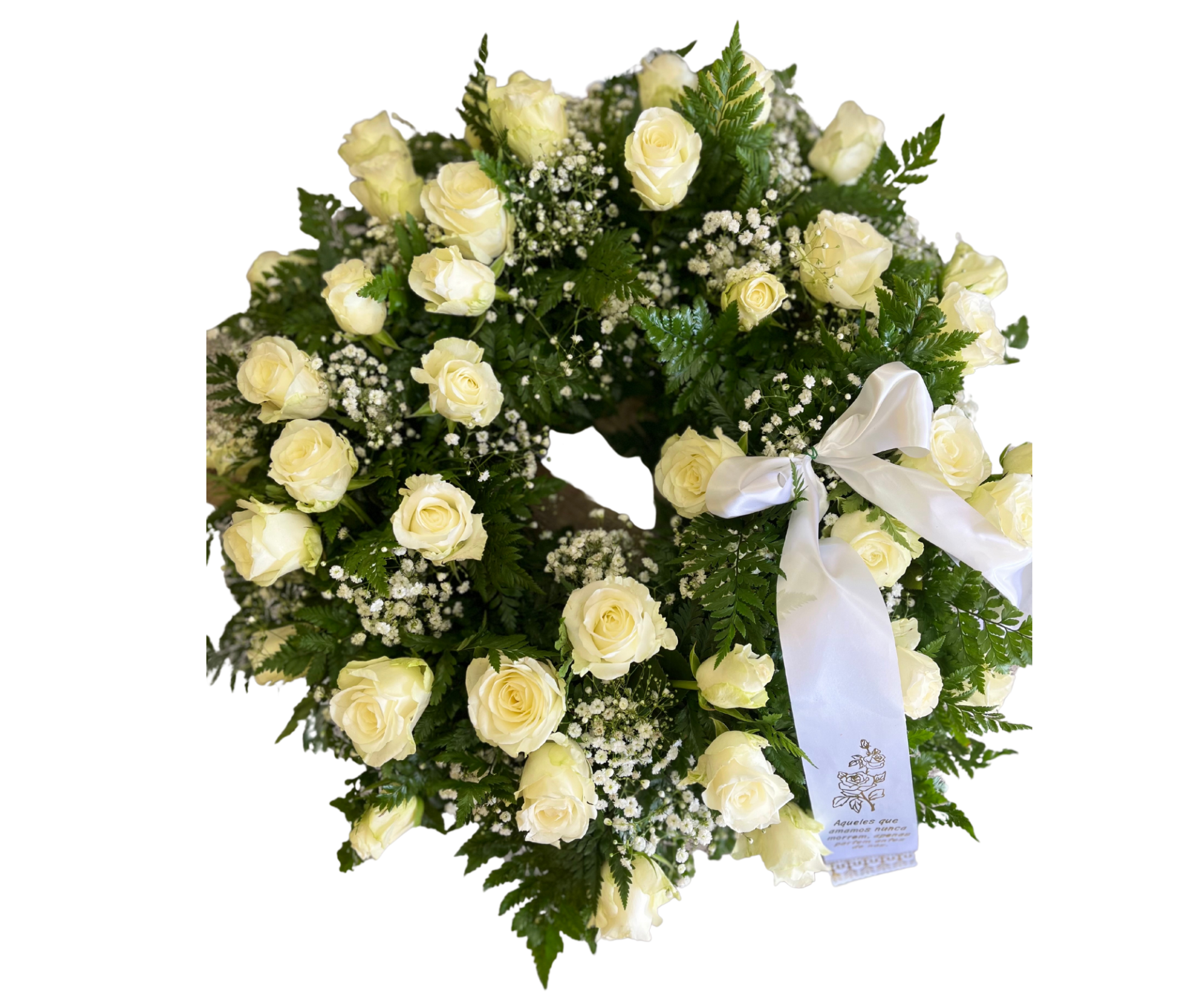 Coroa funebre com rosas brancas, folhas verdes e laço branco com texto.