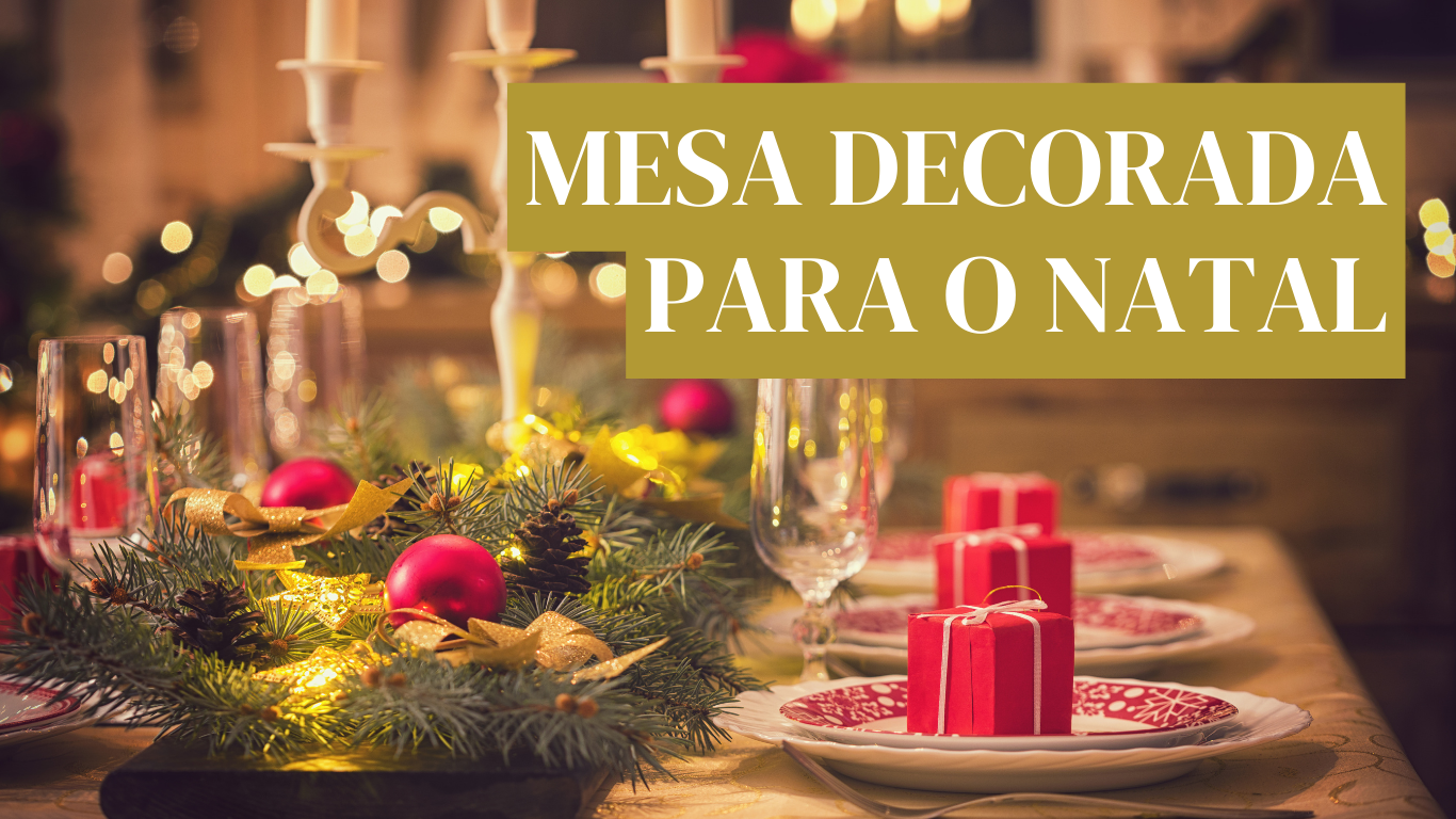 Mesa decorada para Natal com arranjo verde, bolas vermelhas, velas, pratos e caixas de presente vermelhas.