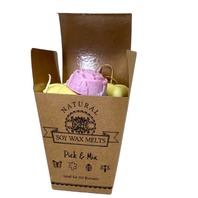 Caixa de cartão castanho aberta com ceras aromáticas de soja de cores rosa, amarela e verde clara.