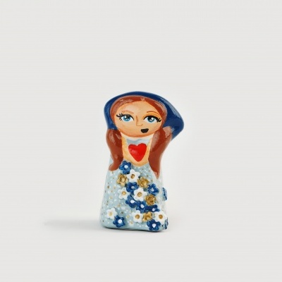 Figura decorativa em cerâmica com vestido florido e coração vermelho no peito