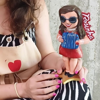 Boneca decorativa vestida de vermelho com acordeão e texto Rosinha